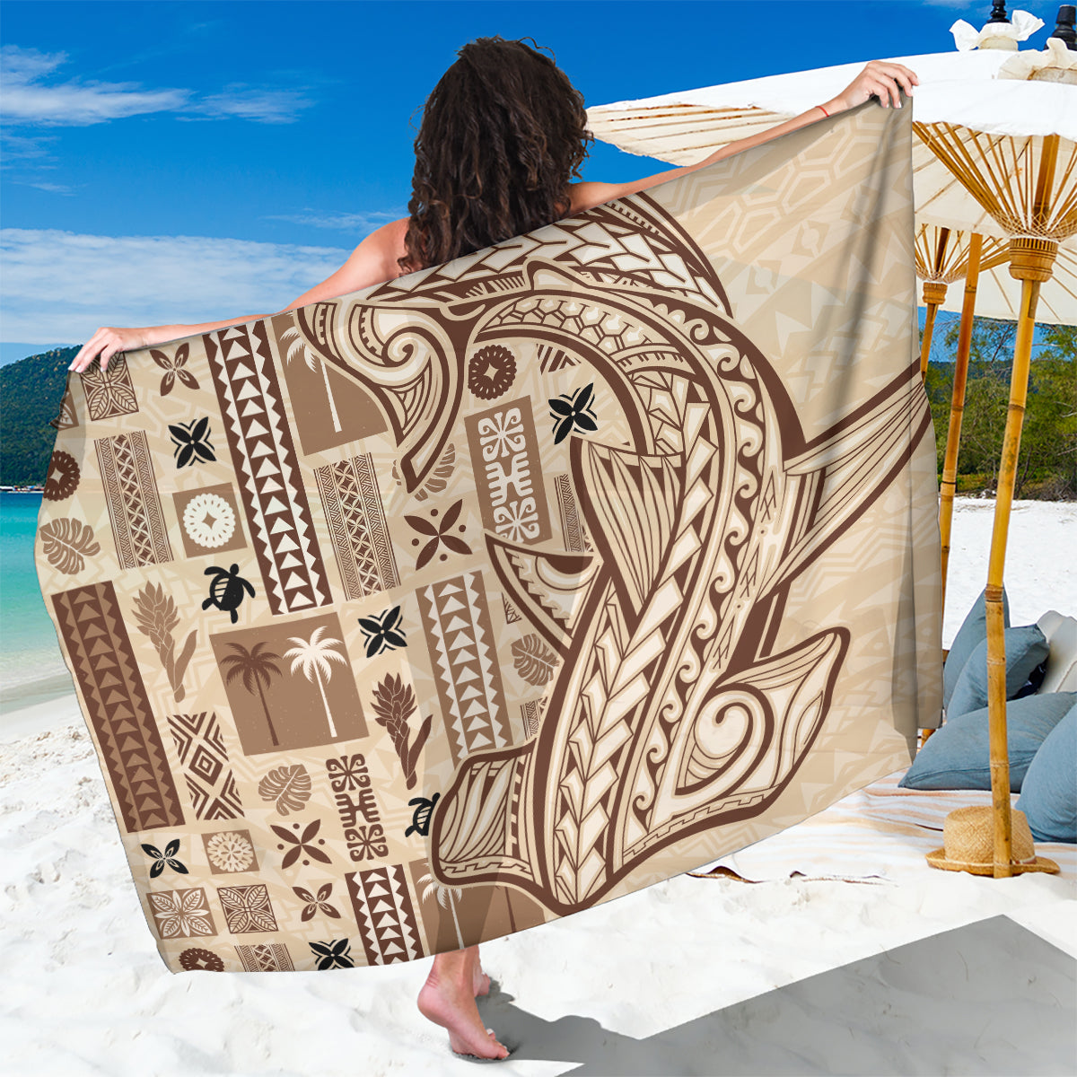 Beige tapa-pattern sarong with brown geometric tiki motifs, folded and held up.