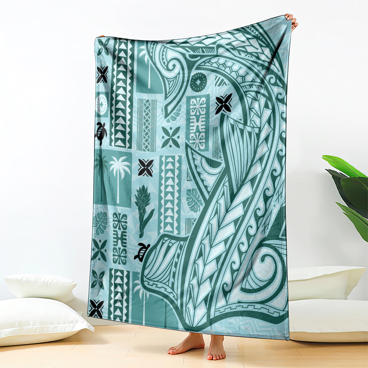 Teal tapa pattern blanket with bold tribal motifs, shown draped upright