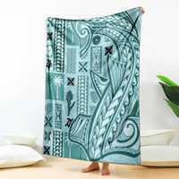 Teal tapa pattern blanket with bold tribal motifs, shown draped upright