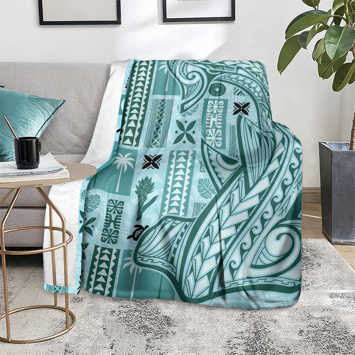 Teal tapa pattern blanket with geometric motifs, folded over the arm of a chair