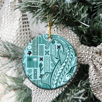 Teal circular ceramic tapa ornament hanging on Christmas tree with gold loop