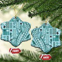 Teal bell-shaped ceramic ornament with tapa patterns, gold hanging loop on tree
