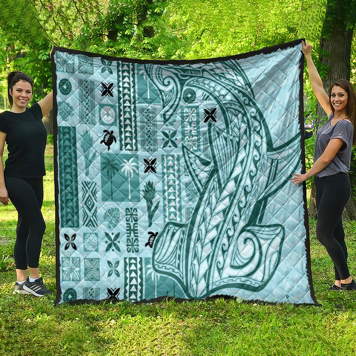 Teal tapa quilt with large swirl motif, small icon patterns, and black border