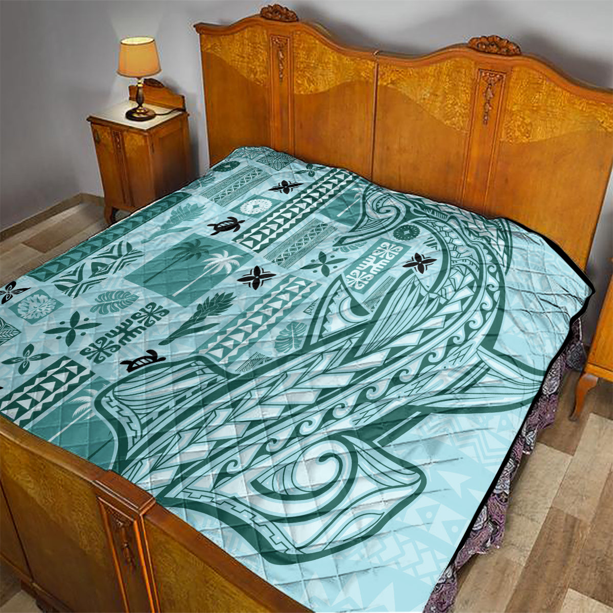 Teal quilt blanket on bed with stitched pattern and black-edged border