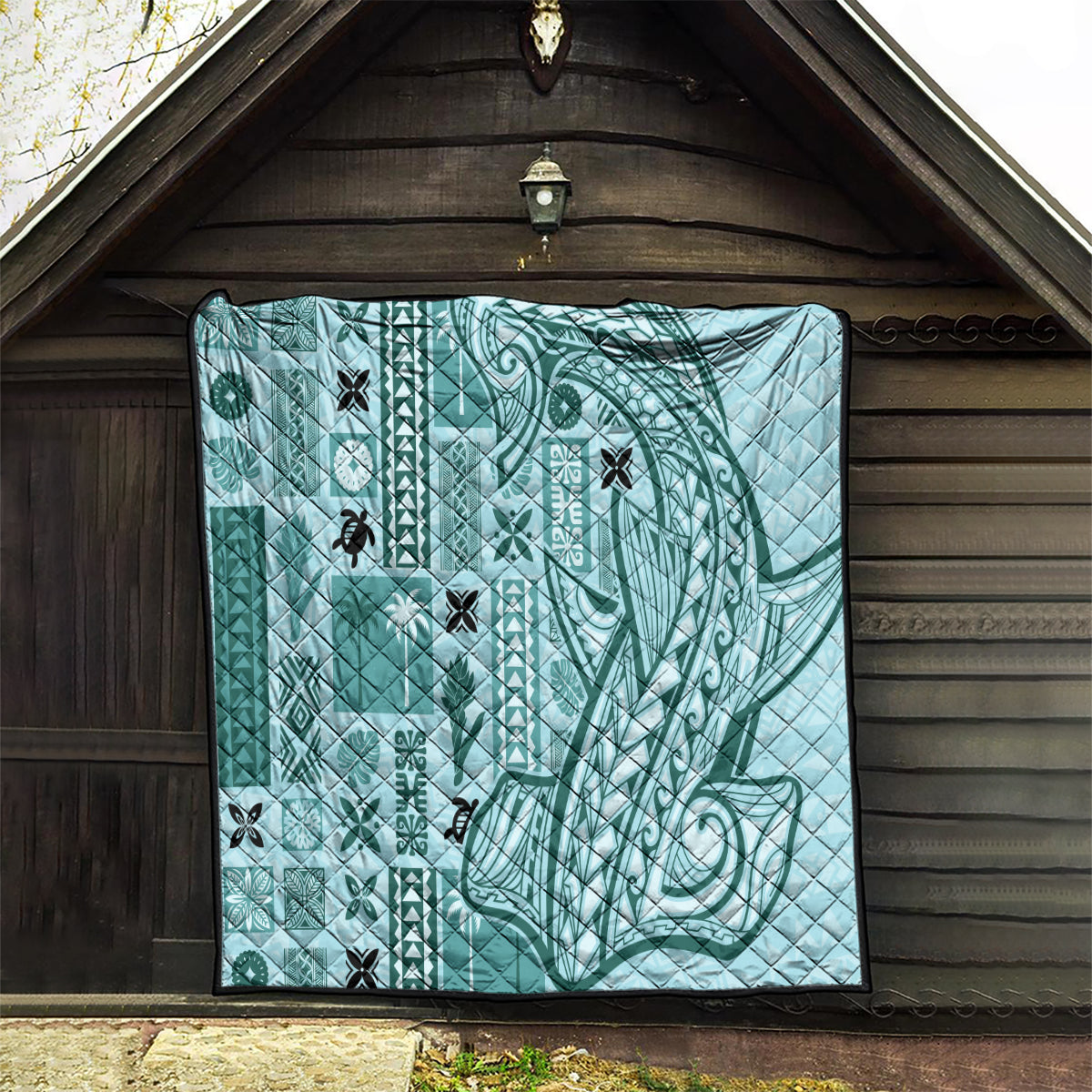 Teal tapa quilt set in an entry doorway, geometric and swirl motifs with black trim