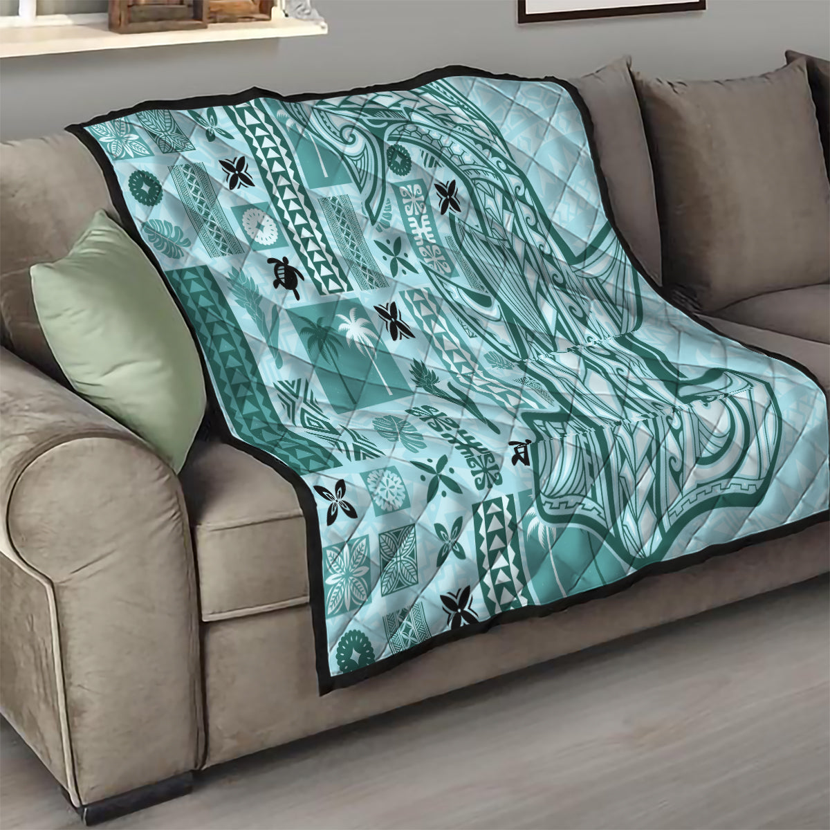 Teal tapa quilt on sofa with geometric swirls, patch motifs, and black border
