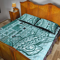 Teal tapa quilt and two pillow shams with black piping on a wooden bed