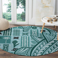 Round teal carpet with bold tapa symbols and leaf scroll design