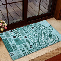 Teal rubber doormat with bold central tribal curves and small turtle icons