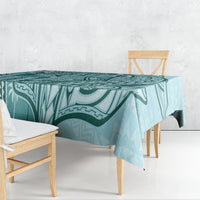 Teal geometric tapa-pattern tablecloth draped over dining table