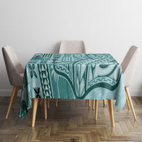 Teal tapa-pattern tablecloth on table with four gray chairs