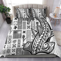 White and black Tapa-pattern bedding set with large tribal motif, draped on bed