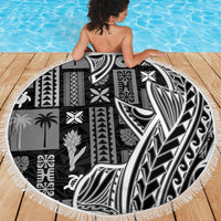 Round beach blanket with bold black-and-white tapa/tatau motifs and white fringe border.