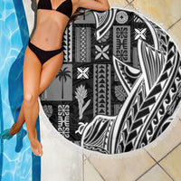 Round beach blanket with black-and-white tapa/tatau motifs and white fringe trim, close-up.