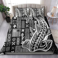 Black and white tapa-pattern bedding set with feather and swirl motifs on bed