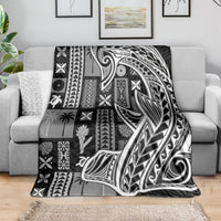 Samoan tapa-style throw blanket draped on sofa, black-and-white geometric tatau patterns