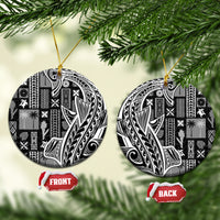 Round black and white tapa ceramic ornament set with gold string on a Christmas tree