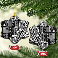 Two heart-shaped black and white tapa ceramic ornaments with gold strings