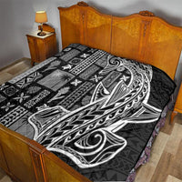 Black and white Tatau-pattern tapa quilt laid on a bed, folded into quilted sections