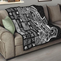 Black Samoa tapa quilt draped on a sofa, quilted geometric grid with Tatau-style face