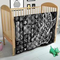 Black and white Samoa tapa quilt spread in a crib, patchwork geometric and face motif