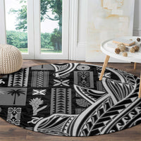 Black round carpet with dense geometric tapa and leaf motifs in white and gray
