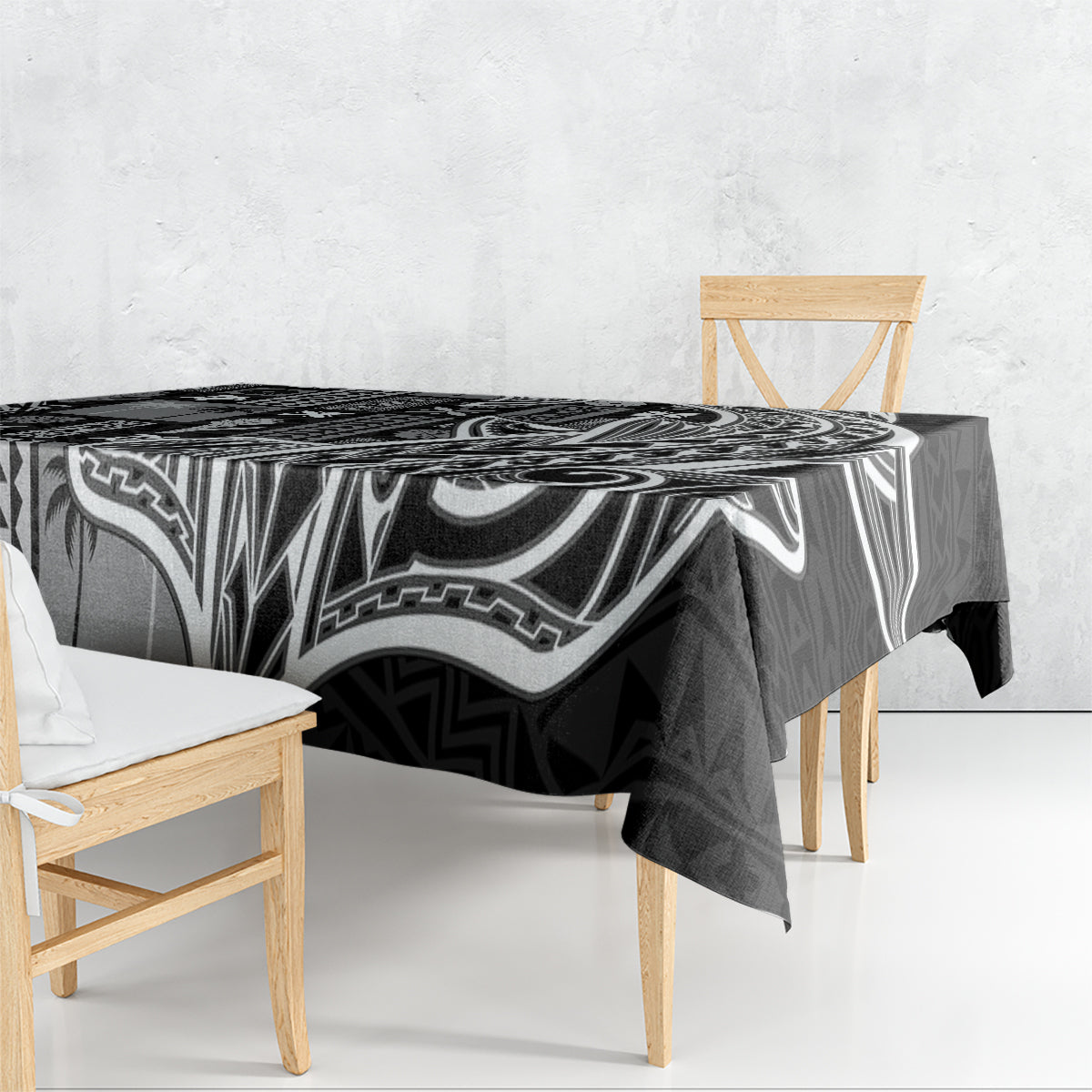 Black and white tapa-pattern tablecloth draped over dining table, corner hanging