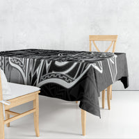 Black and white tapa-pattern tablecloth draped over dining table, corner hanging