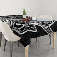 Black tapa-pattern tablecloth covering dining table with chairs and centerpiece