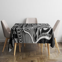 Black tapa patterned tablecloth on dining table with four beige chairs, full coverage