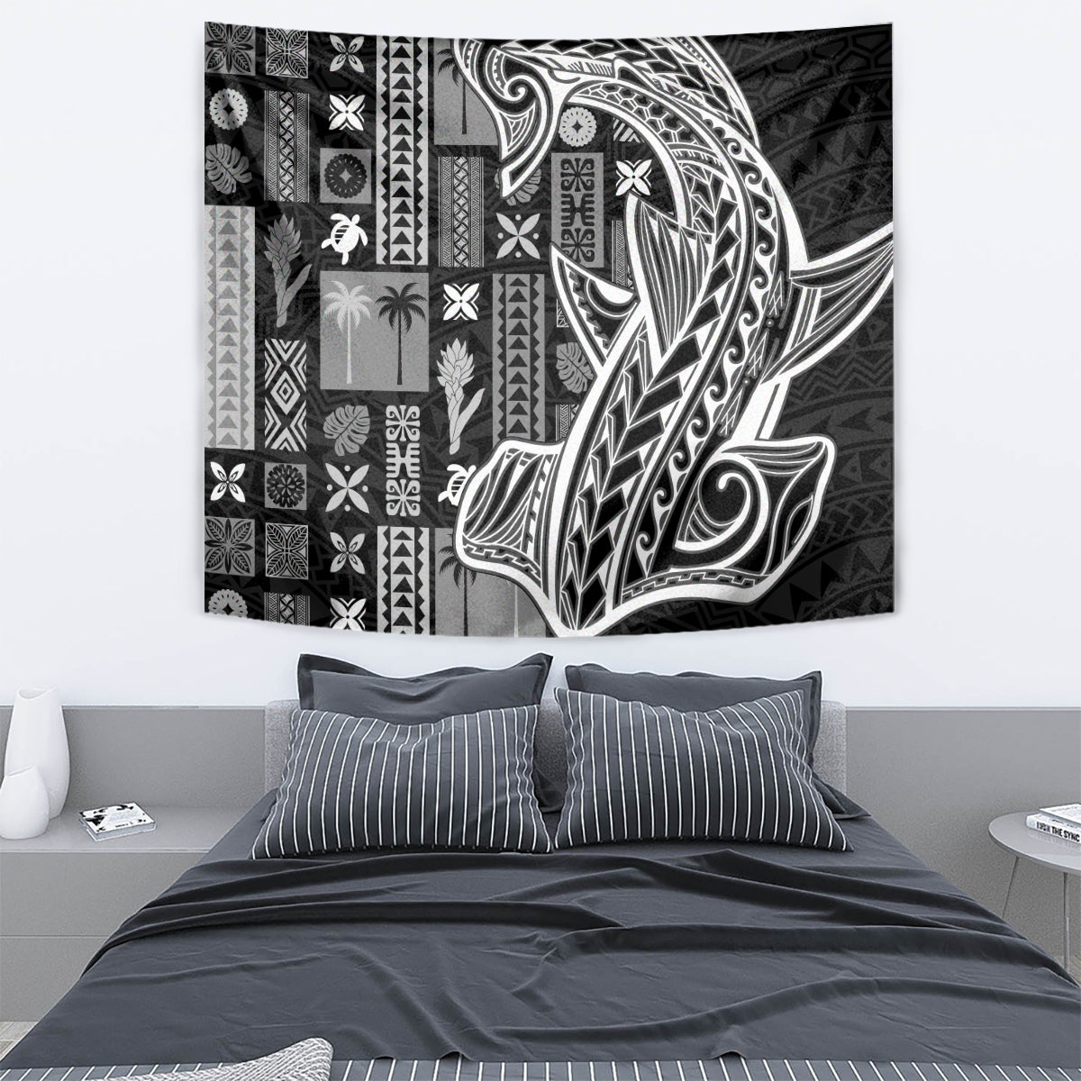 Rectangular wall tapestry in black and white tapa pattern, mounted above bed.
