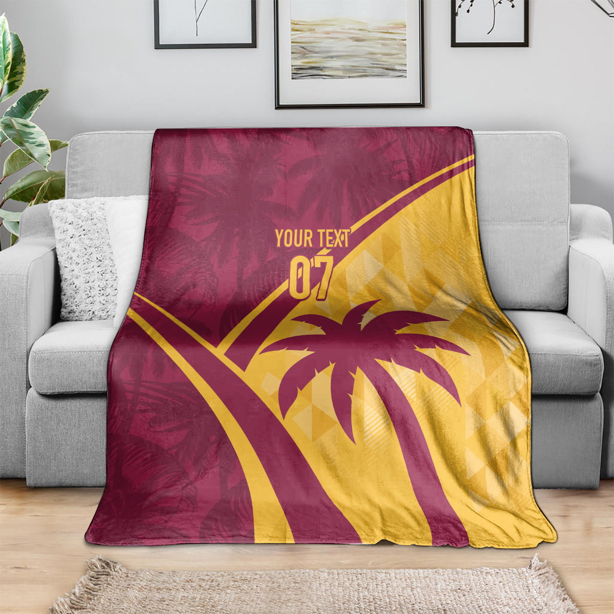 Maroon and yellow tropical blanket laid on a gray sofa with palm tree and “07”