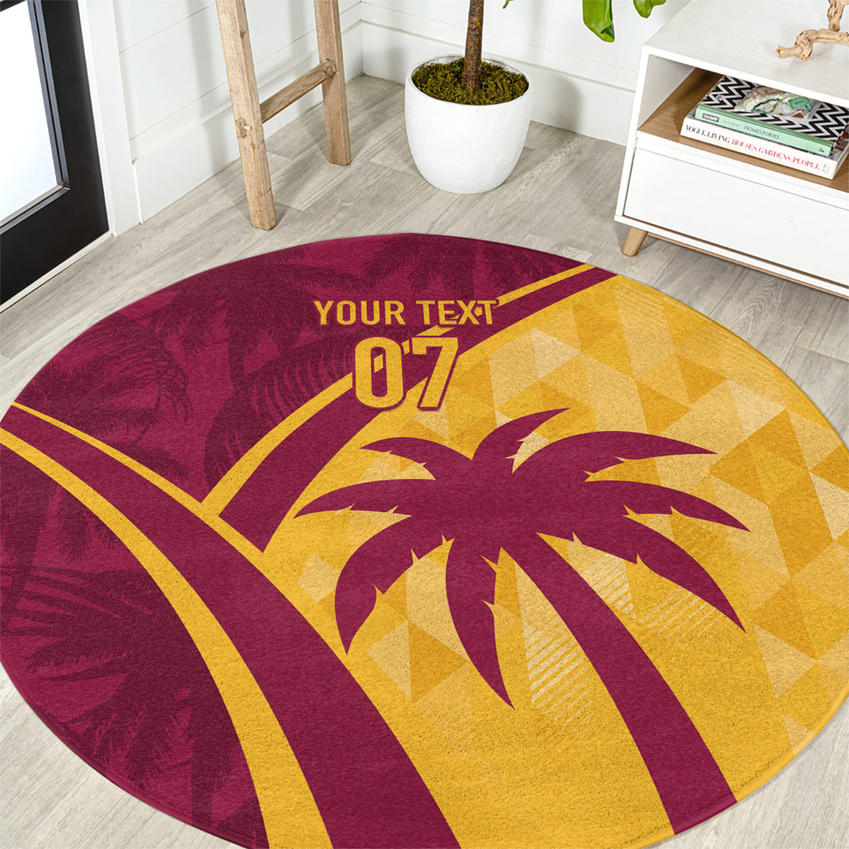 Round maroon and yellow tropical palm graphic area rug shown from a top angle