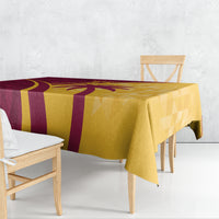 Maroon and yellow tablecloth with tropical palm motif and geometric pattern, draped on table.