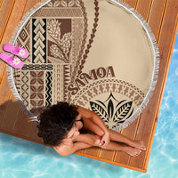 Circular beach blanket with brown geometric panels and leaf emblem, beige background, fringe