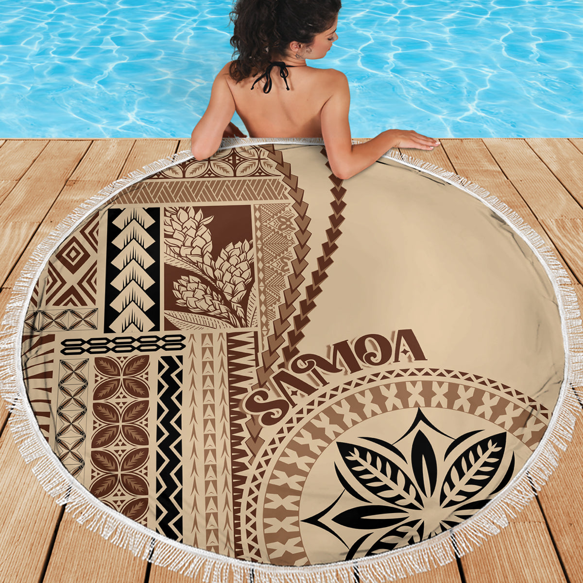Round beach blanket showing full brown and beige Samoan pattern with white tassel trim
