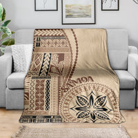 Beige motif blanket draped over sofa, brown geometric pattern and large flower-leaf emblem