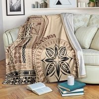Beige motif blanket on bed with brown geometric panels and large leaf emblem