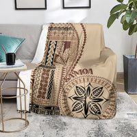 Beige siapo motif blanket on couch, brown geometric blocks and central flower-leaf design