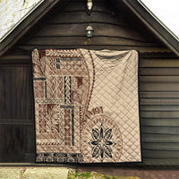Samoa siapo motif quilt hanging in a doorway, beige with brown pattern and leaf emblem
