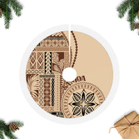 Beige round tree skirt with white fringed edge, central leaf emblem, and circular centerpiece