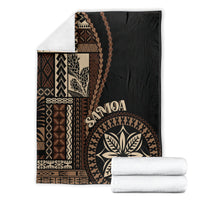 Black Samoa siapo motif blanket with geometric panels, leaf emblem, and rolled white set