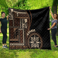 Black Samoa siapo motif quilt blanket with tan geometric panels and large leaf emblem