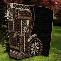 Black Samoa siapo motif quilt blanket with tan patterned panels and leaf emblem