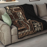 Black Samoa siapo motif quilt blanket on sofa with tan geometric panels and leaf emblem