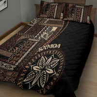 Black siapo motif quilt bed set featuring leaf emblem and geometric border across bed