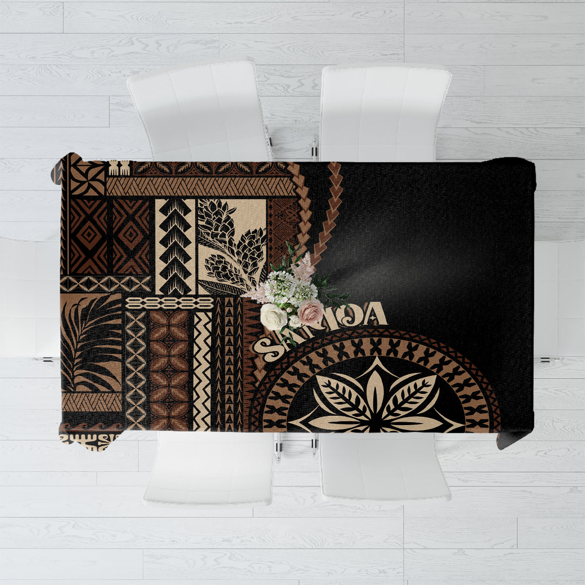 Black siapo motif tablecloth with geometric and leaf patterns, folded over table edge
