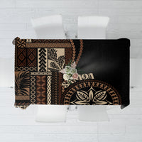 Black siapo motif tablecloth with geometric and leaf patterns, folded over table edge
