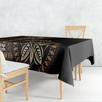 Black tablecloth with woven-style geometric and leaf motifs, draped over a dining table