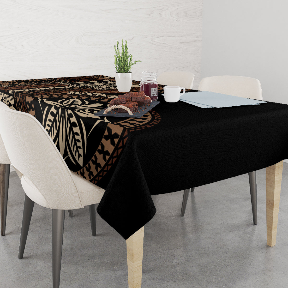 Black siapo motif tablecloth with bold leaf and geometric designs, on a dining table